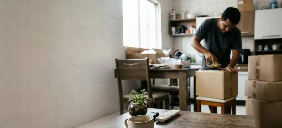 homem embalando encomenda na cozinha